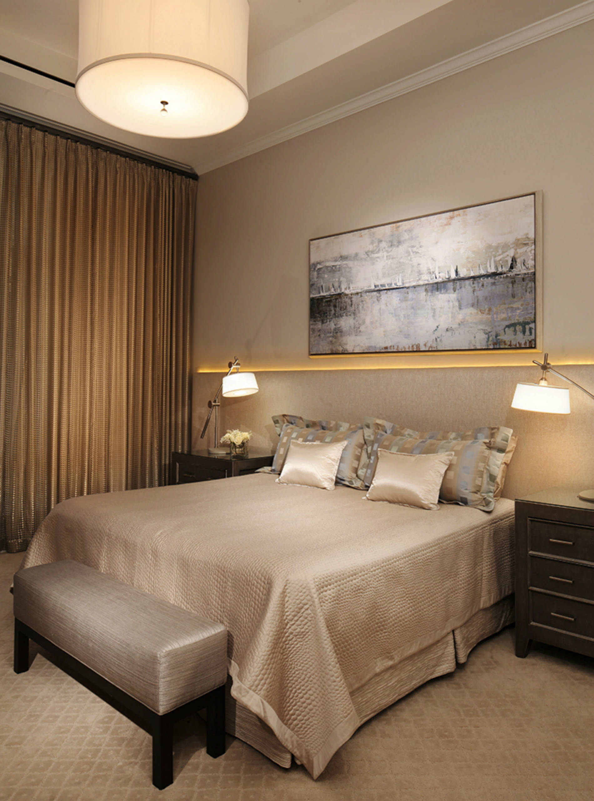 This peaceful bedroom is illuminated by a drum chandelier, two bedside reading lamps and a wall-to-wall headboard with LED rope lighting.