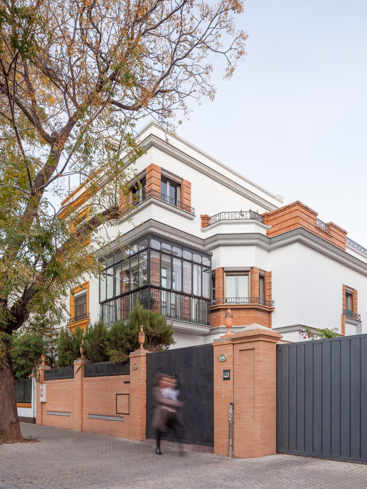 Inspiration for a large contemporary two-storey brick white house exterior in Seville with a flat roof.