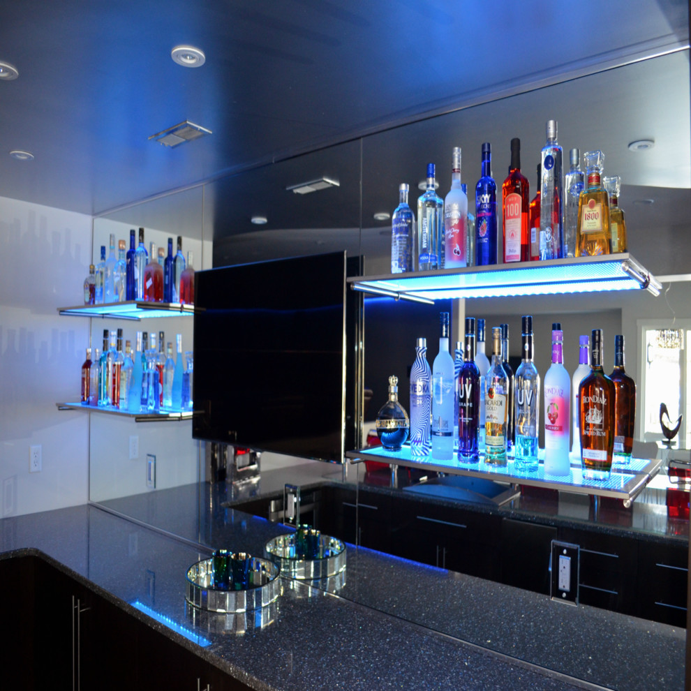 This is an example of a mid-sized modern galley seated home bar in Omaha with flat-panel cabinets, dark wood cabinets, terrazzo benchtops and mirror splashback.