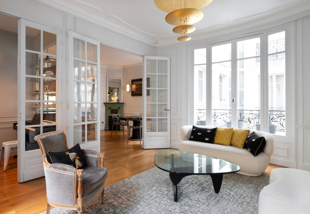 Medium sized traditional grey and white living room in Paris with grey walls, medium hardwood flooring and a standard fireplace.