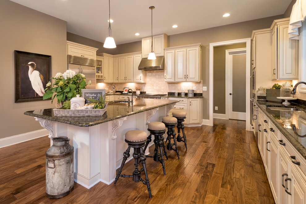 Traditional kitchen in DC Metro with a double-bowl sink, raised-panel cabinets, beige cabinets, beige splashback, stainless steel appliances, dark hardwood floors and with island.