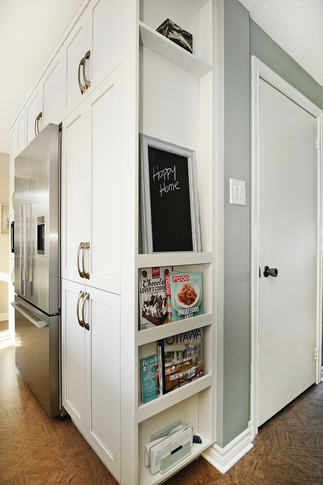 Example of a mid-sized transitional cork floor enclosed kitchen design in Ottawa with an undermount sink, shaker cabinets, white cabinets, granite countertops, gray backsplash, ceramic backsplash, stainless steel appliances and an island