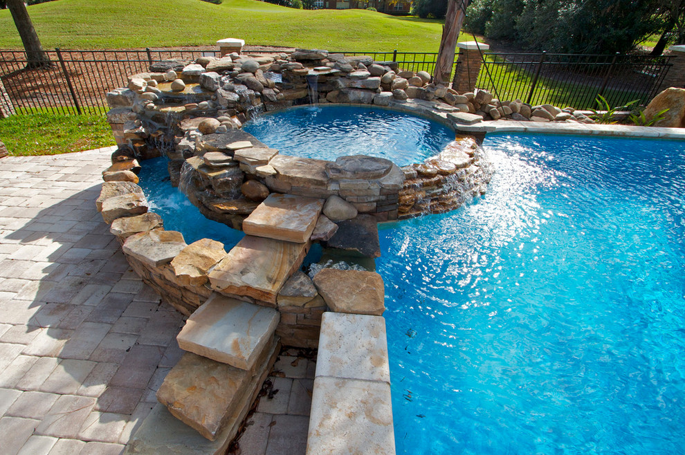 Inspiration for a large backyard brick and custom-shaped natural hot tub remodel in Jacksonville