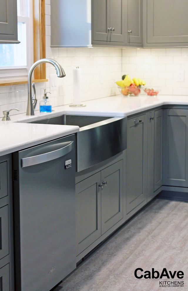 Enclosed kitchen - small transitional l-shaped laminate floor and gray floor enclosed kitchen idea with a farmhouse sink, recessed-panel cabinets, gray cabinets, quartz countertops, white backsplash, subway tile backsplash, stainless steel appliances and a peninsula