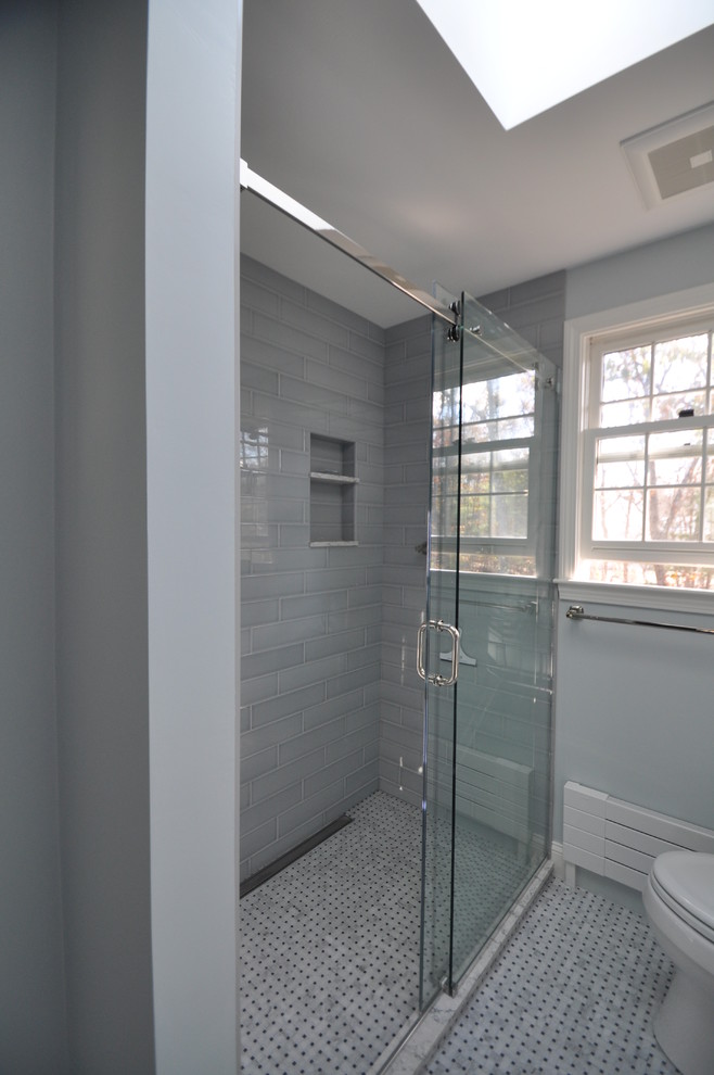 Design ideas for a mid-sized traditional master bathroom in Boston with recessed-panel cabinets, white cabinets, an alcove shower, a two-piece toilet, gray tile, ceramic tile, grey walls, mosaic tile floors, an undermount sink, engineered quartz benchtops and a sliding shower screen.