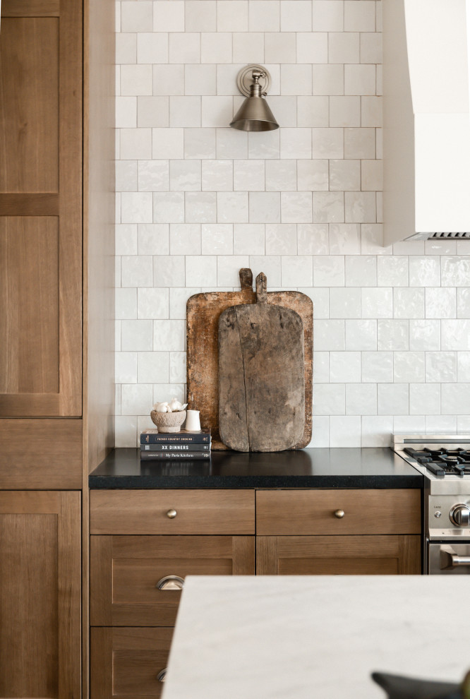 Exempel på ett stort klassiskt svart svart kök och matrum, med en undermonterad diskho, skåp i shakerstil, skåp i mellenmörkt trä, granitbänkskiva, vitt stänkskydd, stänkskydd i keramik, rostfria vitvaror och ljust trägolv