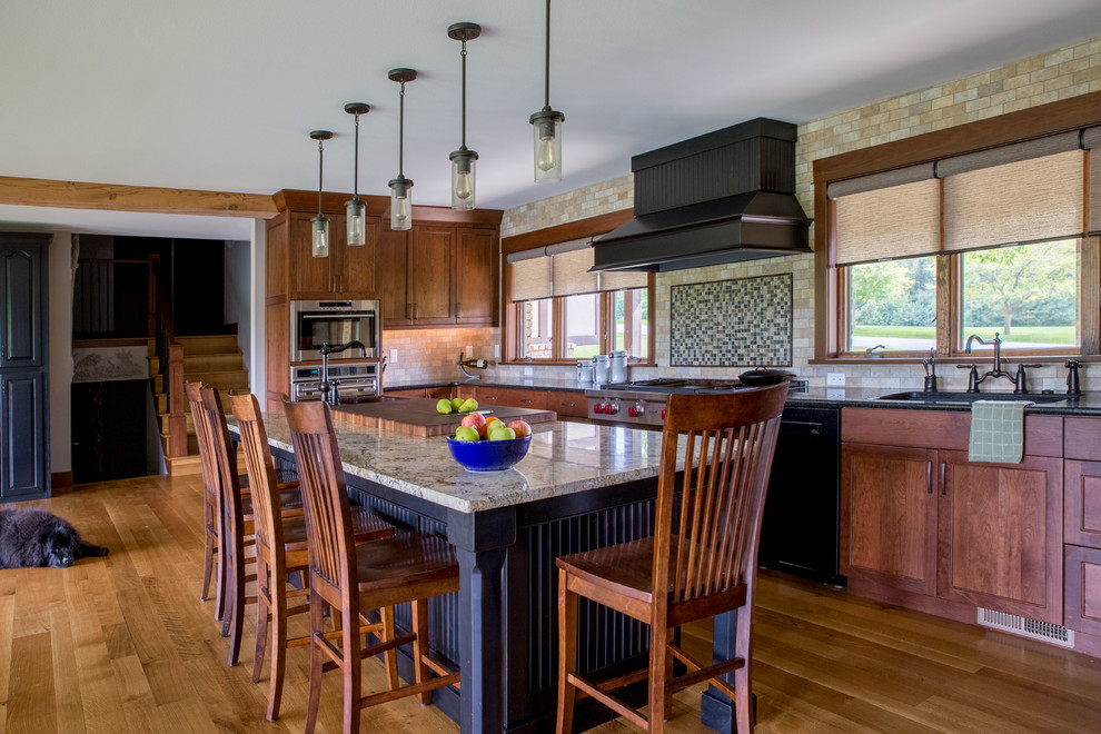 Eat-in kitchen - large rustic galley light wood floor and beige floor eat-in kitchen idea in Cedar Rapids with recessed-panel cabinets, medium tone wood cabinets, granite countertops, beige backsplash, stone tile backsplash, black appliances, an island, multicolored countertops and an undermount sink