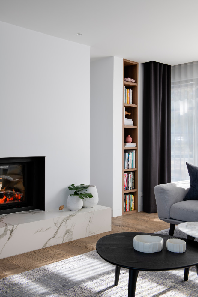 Inspiration for a mid-sized contemporary formal loft-style living room in Sydney with white walls, medium hardwood floors, a standard fireplace and a wall-mounted tv.