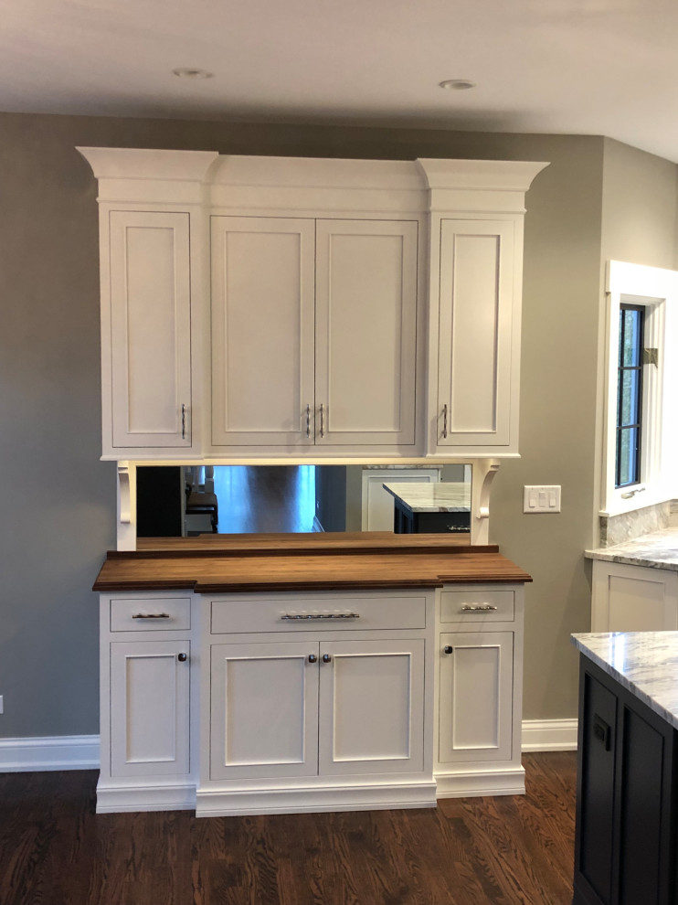 Transitional eat-in kitchen photo in Chicago with white backsplash, stainless steel appliances and an island