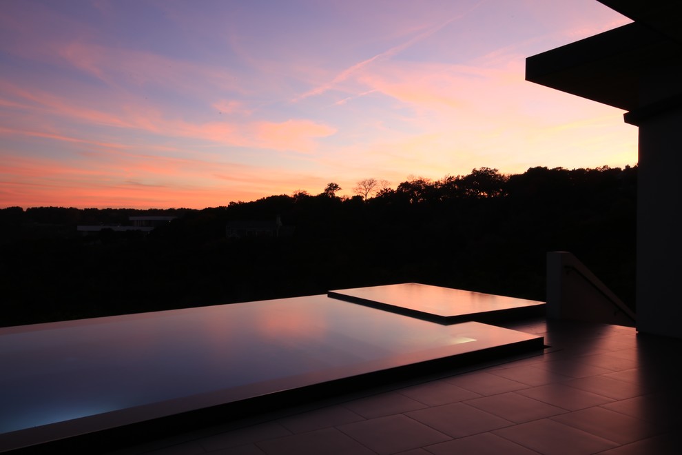 Inspiration for a large modern backyard concrete paver and rectangular aboveground pool fountain remodel in Austin