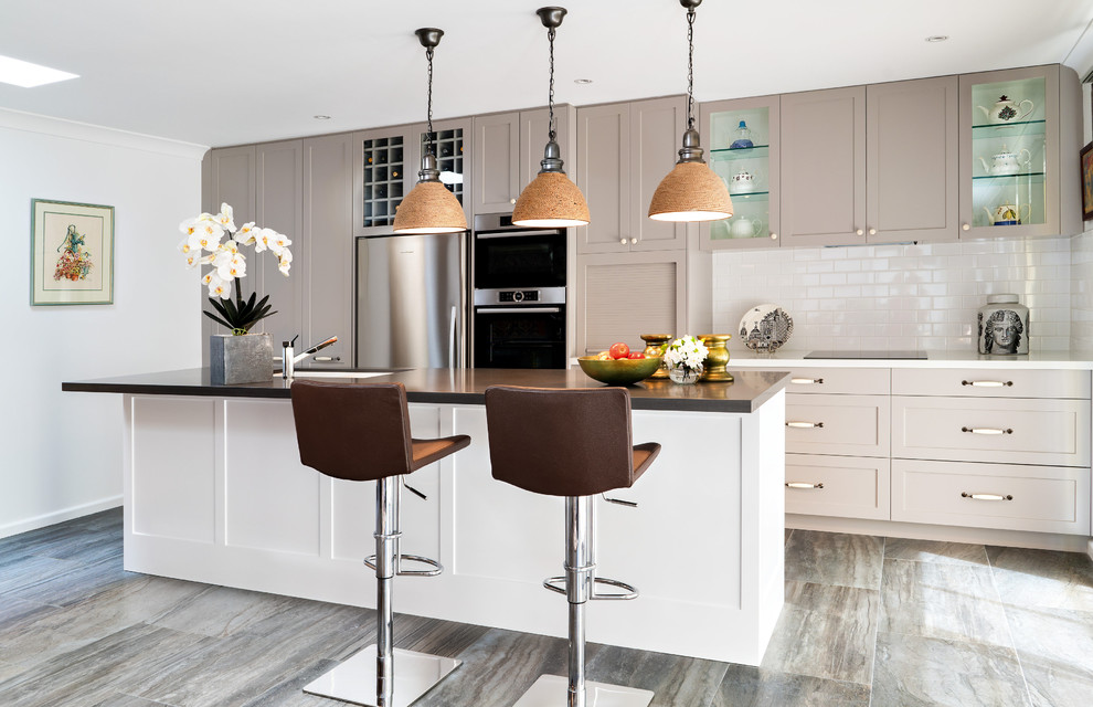 Inspiration for a mid-sized transitional galley kitchen in Sydney with a double-bowl sink, shaker cabinets, grey cabinets, quartz benchtops, white splashback, porcelain splashback, stainless steel appliances, ceramic floors and with island.