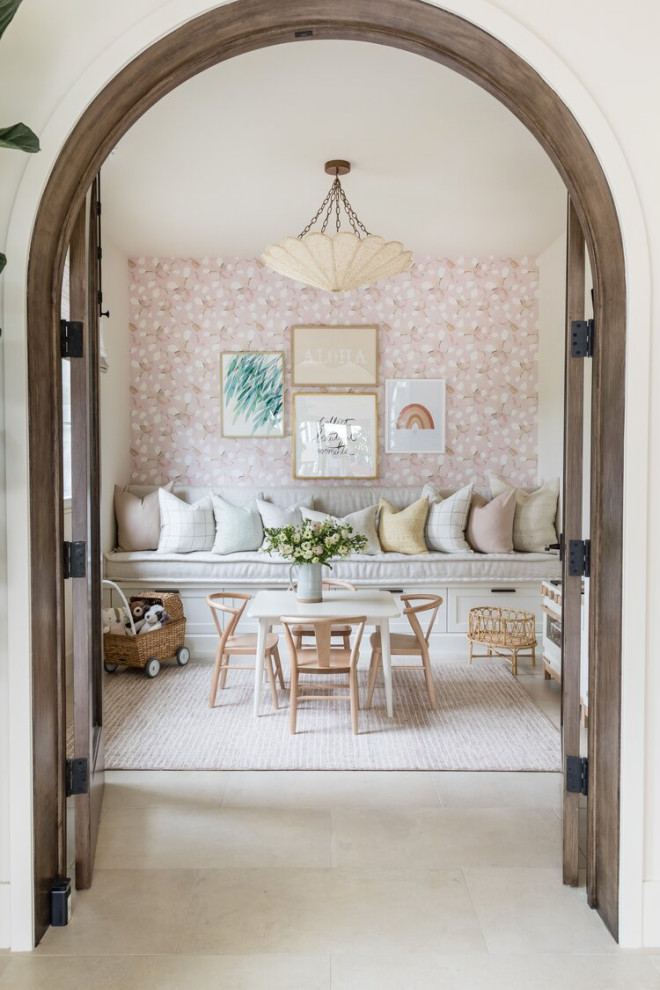 Inspiration for a beach style kids' playroom for girls in Orange County with pink walls, grey floor and wallpaper.