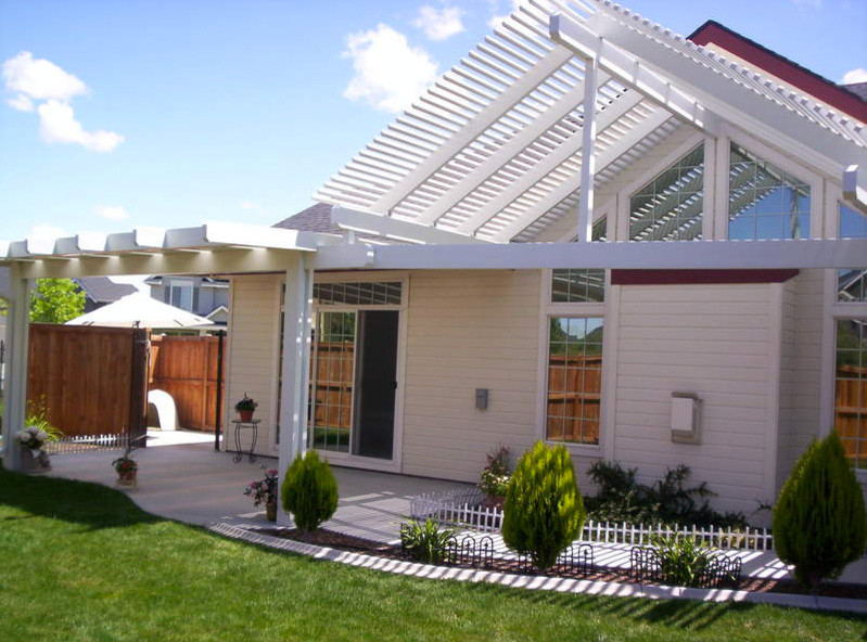 Mid-sized transitional backyard concrete patio photo in Boise with a roof extension