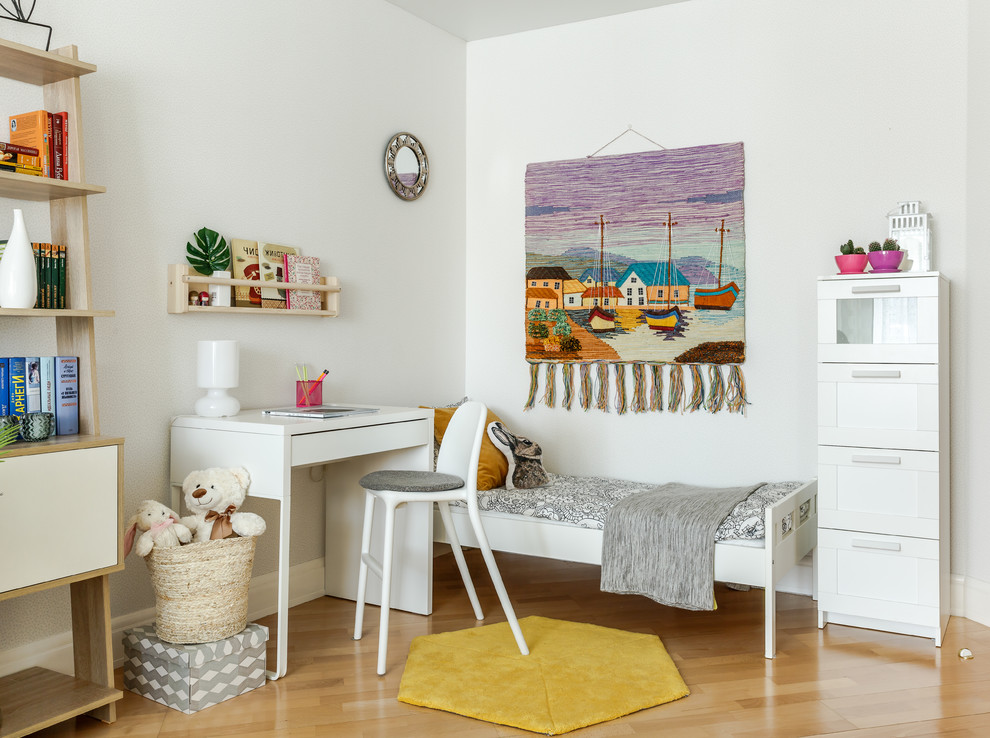 This is an example of a scandinavian kids' bedroom for kids 4-10 years old and girls in Other with white walls, light hardwood floors and beige floor.