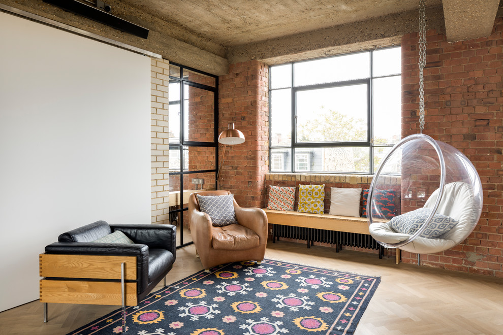 Photo of an industrial living room in London with white walls, light hardwood floors and beige floor.