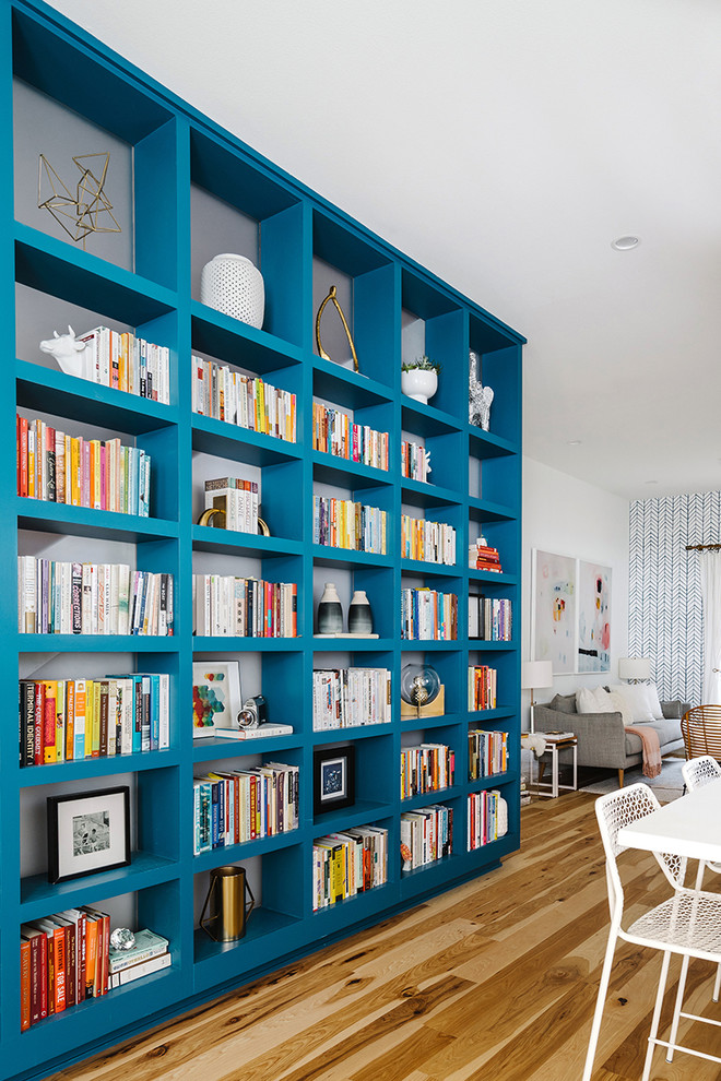 Inspiration for a large scandinavian open concept living room in Austin with a library, white walls, light hardwood floors, no fireplace and no tv.
