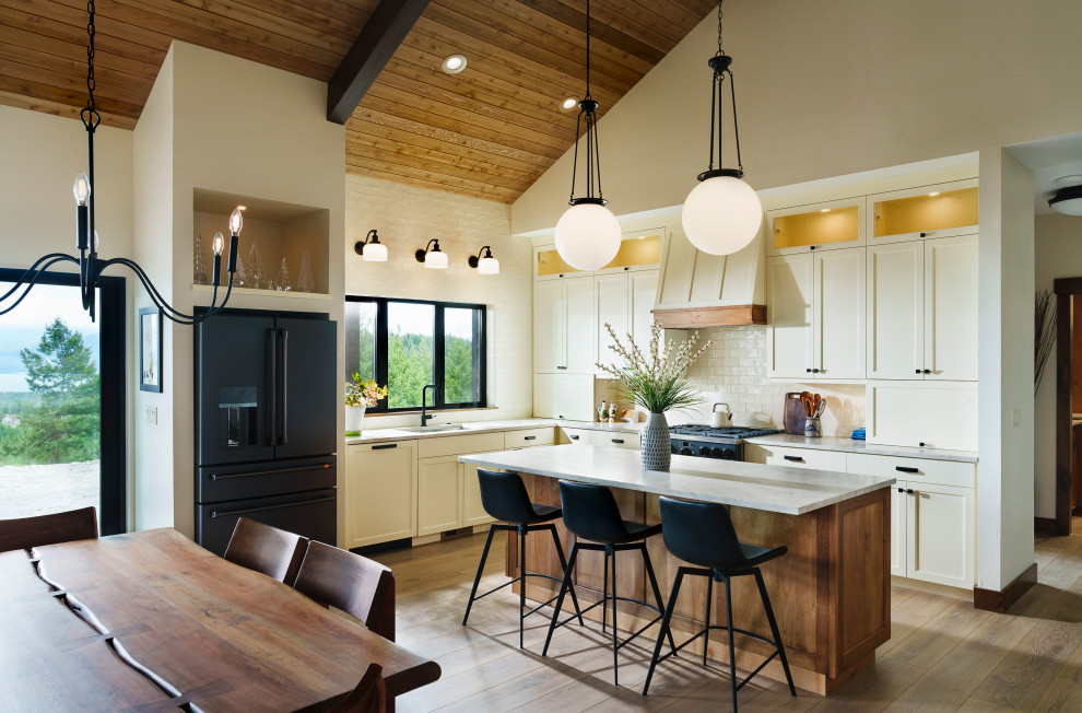 Inspiration for a rustic l-shaped medium tone wood floor, brown floor, vaulted ceiling and wood ceiling eat-in kitchen remodel with an undermount sink, shaker cabinets, white cabinets, white backsplash, subway tile backsplash, black appliances, an island and gray countertops