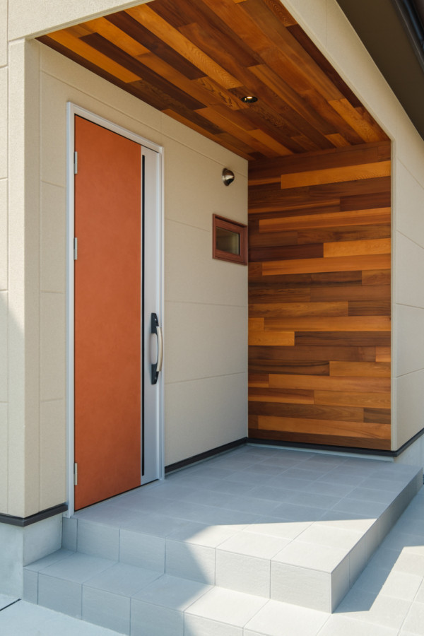 На фото: прихожая с бежевыми стенами, одностворчатой входной дверью, оранжевой входной дверью, серым полом, деревянным потолком и деревянными стенами