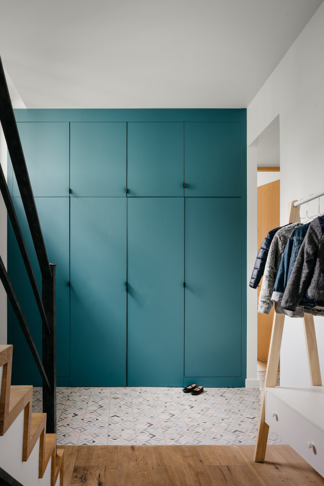 Idéer för minimalistiska foajéer, med blå väggar, ljust trägolv och beiget golv