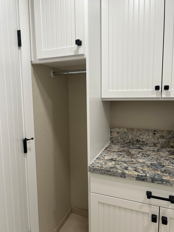 Large traditional single-wall dedicated laundry room in Phoenix with white cabinets, granite benchtops, multi-coloured splashback, granite splashback, beige walls, beige floor and multi-coloured benchtop.