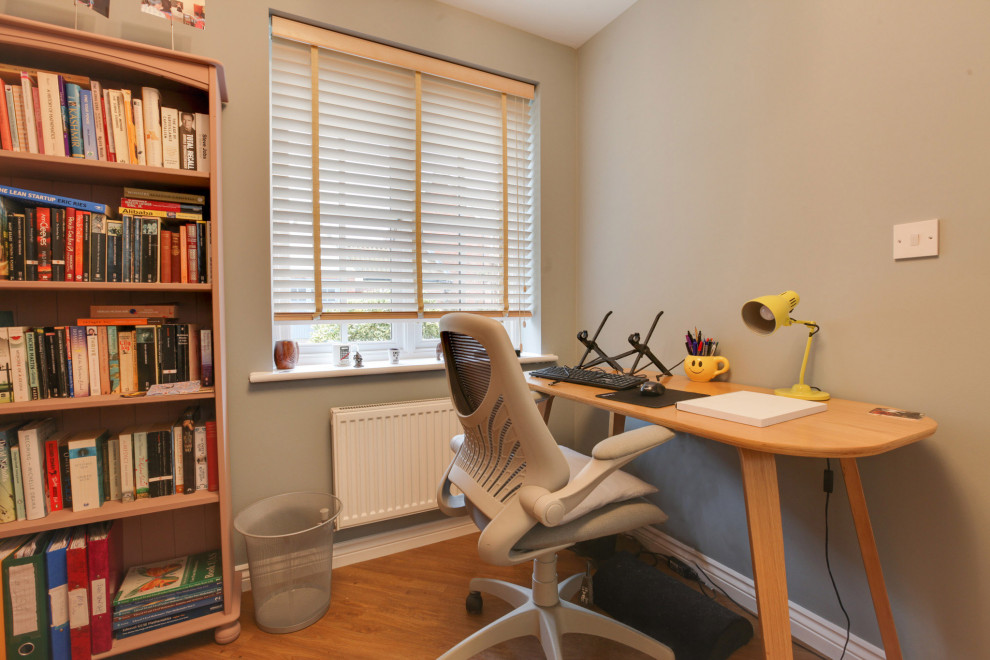エセックスにある低価格の中くらいなコンテンポラリースタイルのおしゃれな書斎 (緑の壁、ラミネートの床、自立型机) の写真