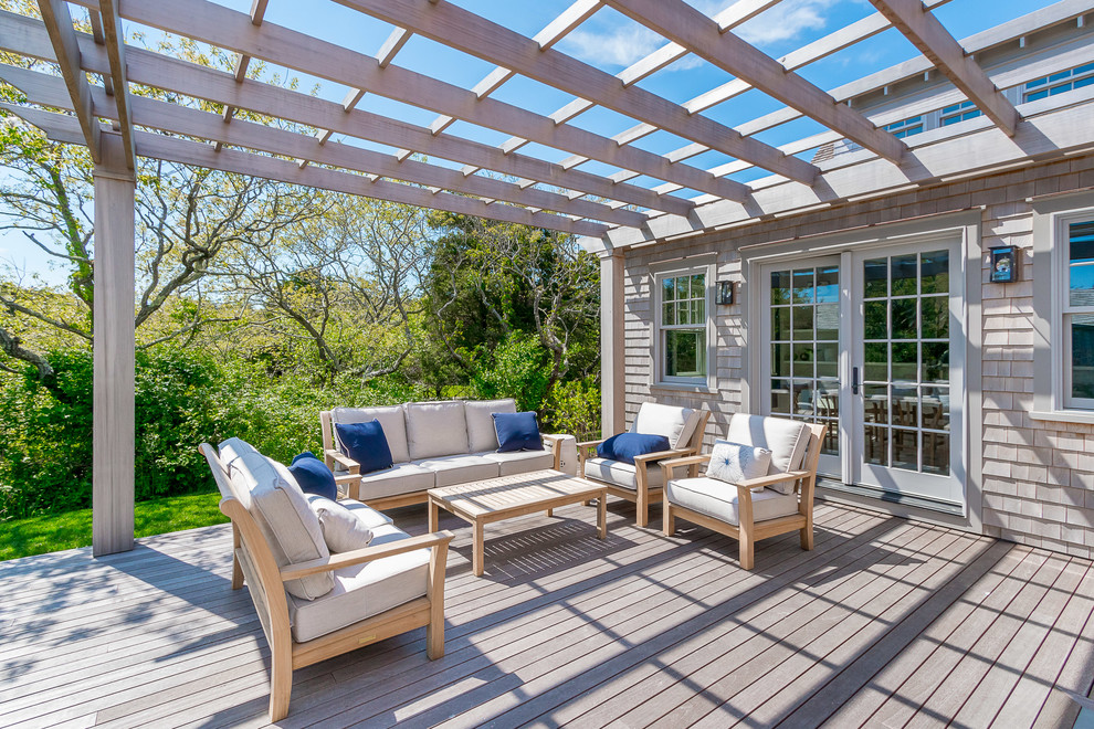 This is an example of a beach style backyard deck in Other with a pergola.
