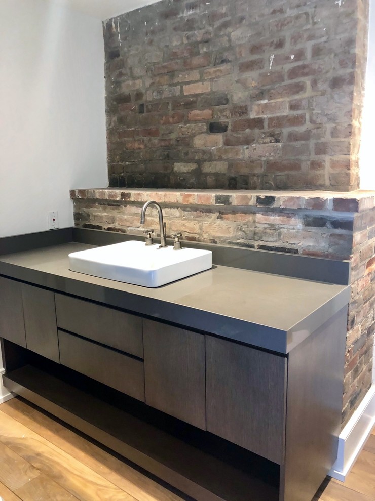Inspiration for a mid-sized contemporary 3/4 bathroom in New Orleans with flat-panel cabinets, dark wood cabinets, medium hardwood floors, a vessel sink and engineered quartz benchtops.