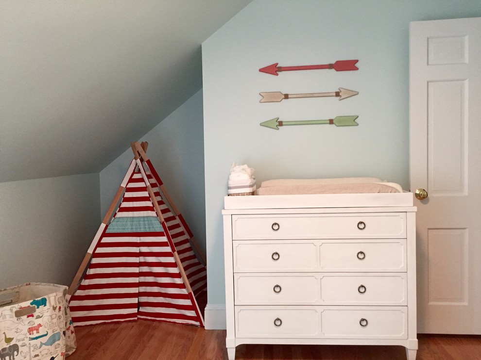 Design ideas for a mid-sized modern gender-neutral nursery in Boston with blue walls and medium hardwood floors.