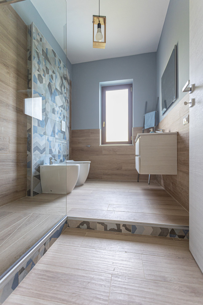Inredning av ett modernt litet vit vitt toalett, med skåp i ljust trä, en toalettstol med separat cisternkåpa, beige kakel, blå väggar, ett integrerad handfat, laminatbänkskiva och brunt golv