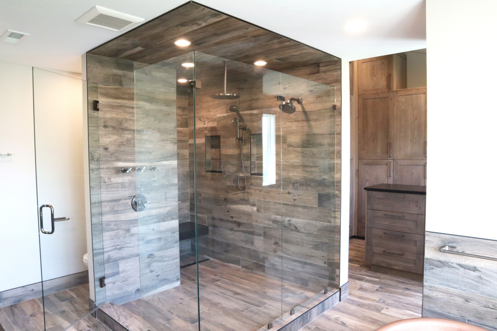 Cette image montre une salle de bain principale rustique en bois brun de taille moyenne avec un placard à porte vitrée, une douche d'angle, un mur marron, un sol marron, une cabine de douche à porte battante, un banc de douche et meuble-lavabo encastré.
