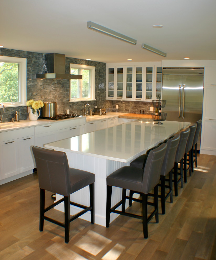 Inspiration for a mid-sized transitional l-shaped open concept kitchen remodel with an undermount sink, shaker cabinets, white cabinets, quartz countertops, blue backsplash, glass tile backsplash, stainless steel appliances, white walls, engineered wood floors and an island