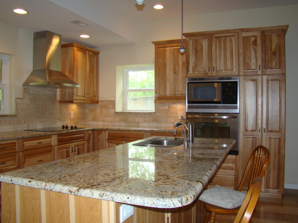 Inspiration for a mid-sized transitional l-shaped light wood floor eat-in kitchen remodel in Denver with an undermount sink, raised-panel cabinets, light wood cabinets, multicolored backsplash, subway tile backsplash, stainless steel appliances and an island