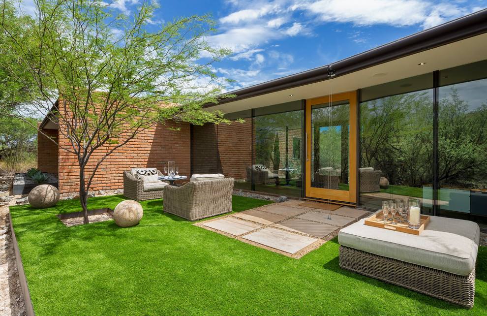 This is an example of a midcentury backyard garden in Phoenix with with lawn edging.