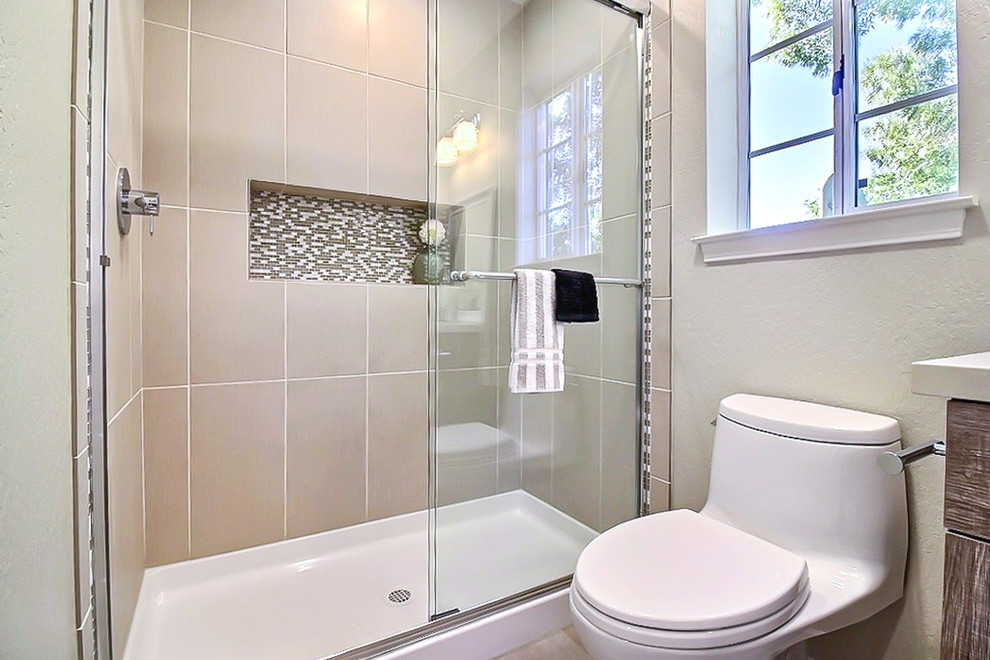 Inspiration for a small traditional 3/4 bathroom in San Francisco with shaker cabinets, light wood cabinets, an alcove shower, a one-piece toilet, beige tile, white tile, mosaic tile, beige walls, travertine floors, an undermount sink and solid surface benchtops.