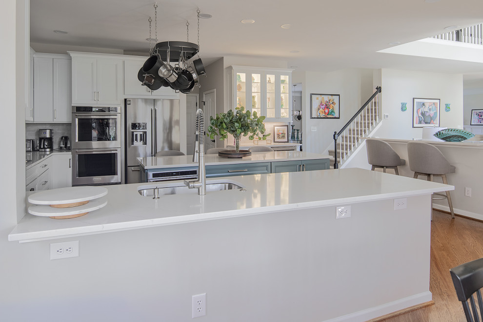 Inspiration for an expansive traditional u-shaped kitchen/diner in Charlotte with a submerged sink, recessed-panel cabinets, engineered stone countertops, stainless steel appliances, an island and white worktops.