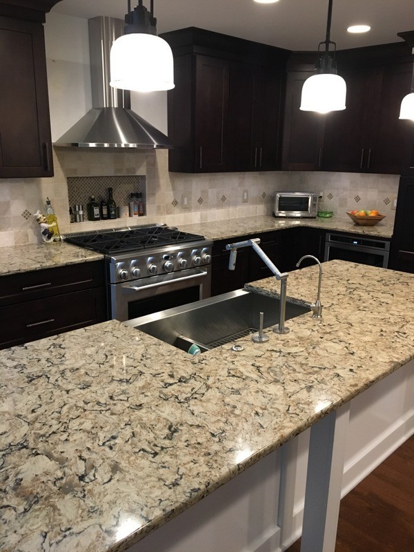 Large transitional u-shaped porcelain tile open concept kitchen photo in Detroit with a farmhouse sink, shaker cabinets, white cabinets, quartz countertops, beige backsplash, stone tile backsplash, stainless steel appliances and an island