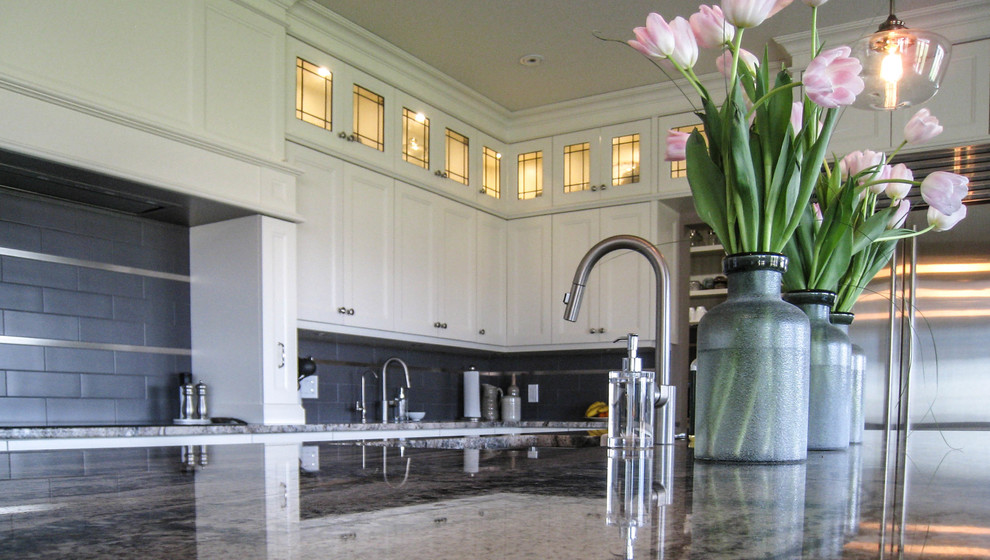 Example of a transitional l-shaped gray floor eat-in kitchen design in Toronto with an undermount sink, white cabinets, granite countertops, gray backsplash, stainless steel appliances and an island