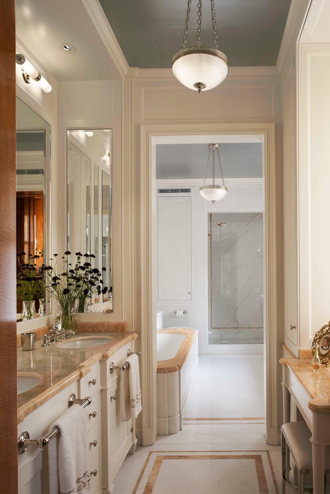 Inspiration for a traditional bathroom in New York with an undermount sink, recessed-panel cabinets, beige cabinets, an undermount tub, an alcove shower and beige walls.