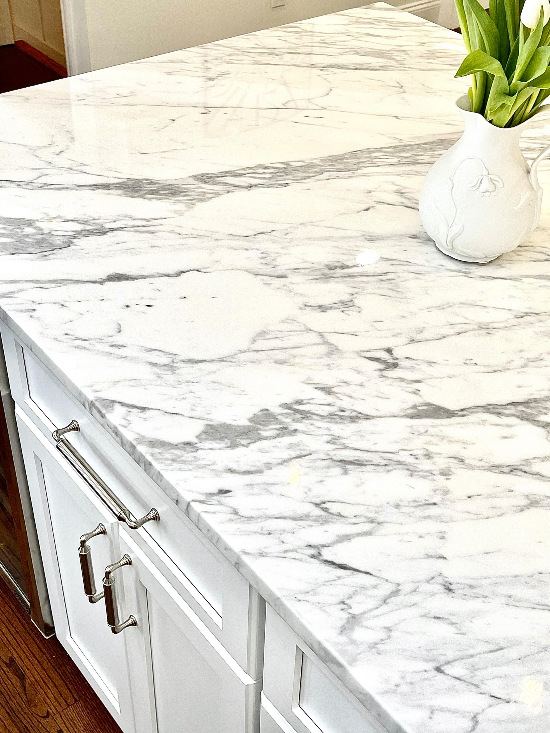 The (literal) centerpiece that gives this space its haute aesthetic is the splurge purchase of a Calcutta Gold Marble slab for the center island countertop.