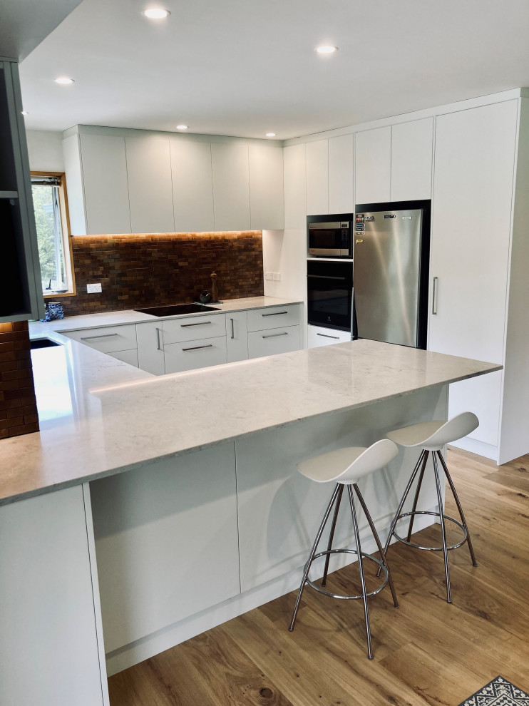 Large trendy u-shaped kitchen photo in Christchurch with quartz countertops