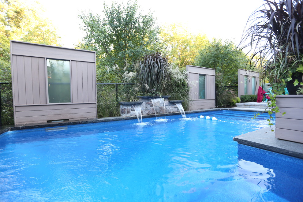 Mid-sized transitional backyard stone and l-shaped natural pool fountain photo in Toronto