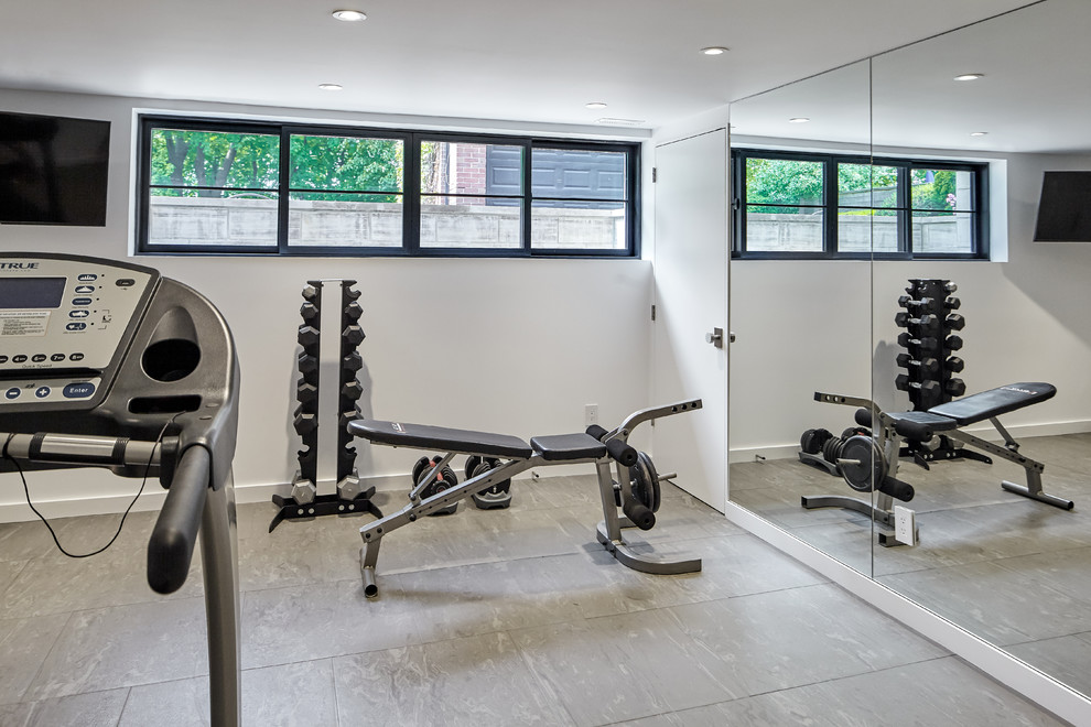 This is an example of a large contemporary home weight room in Toronto with white walls.