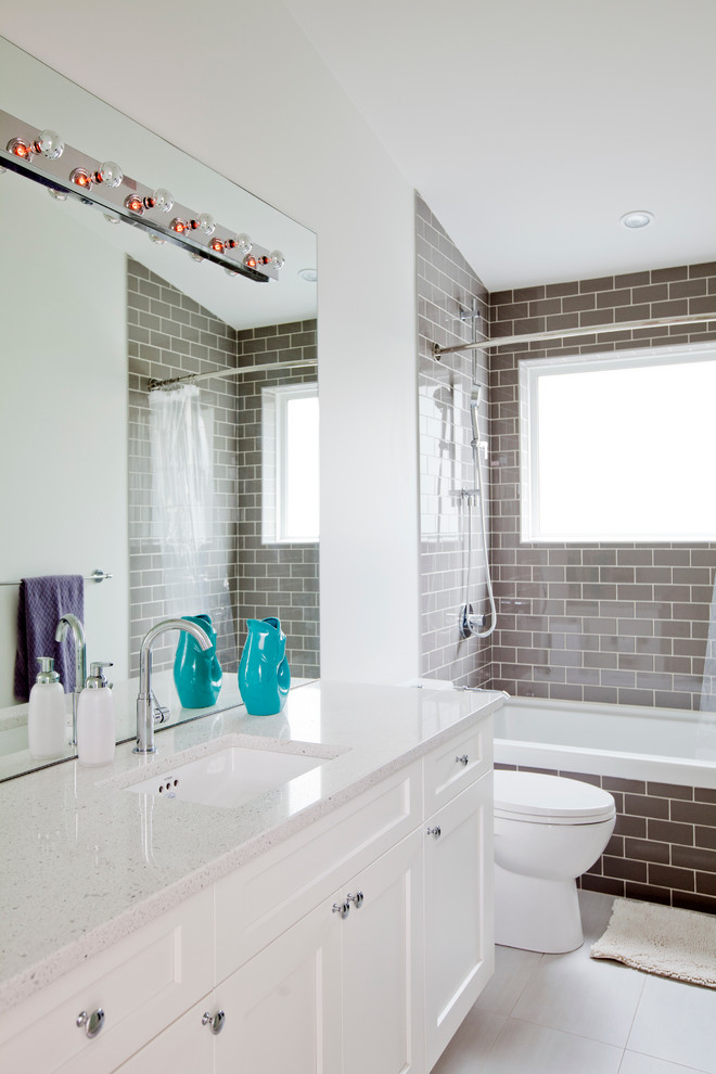 Design ideas for a mid-sized transitional 3/4 bathroom in Vancouver with recessed-panel cabinets, white cabinets, an alcove tub, a shower/bathtub combo, brown tile, subway tile, white walls, porcelain floors, an undermount sink, engineered quartz benchtops and a shower curtain.