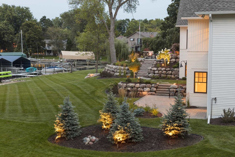 This is an example of a large traditional backyard garden in Minneapolis with a garden path and natural stone pavers.