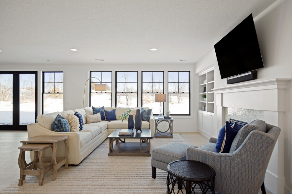 На фото: гостиная комната в стиле неоклассика (современная классика) с белыми стенами, светлым паркетным полом, стандартным камином, фасадом камина из плитки и телевизором на стене