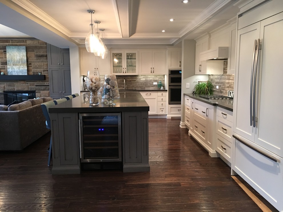 Open concept kitchen - mid-sized transitional l-shaped dark wood floor open concept kitchen idea in Toronto with a double-bowl sink, shaker cabinets, quartz countertops, gray backsplash, stone tile backsplash, paneled appliances and an island