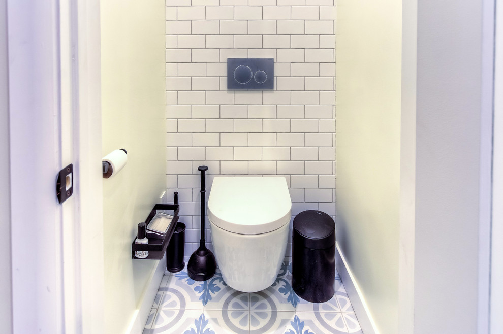 Photo of a mid-sized transitional master bathroom in Los Angeles with flat-panel cabinets, light wood cabinets, a wall-mount toilet, white tile, subway tile, grey walls, cement tiles, engineered quartz benchtops, multi-coloured floor and grey benchtops.