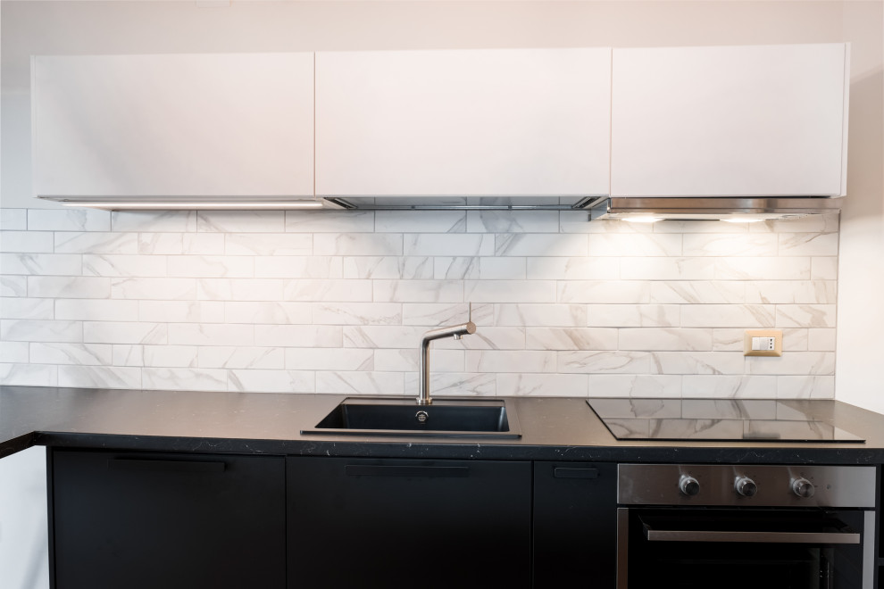 This is an example of a small contemporary l-shaped open plan kitchen in Other with a single-bowl sink, beaded inset cabinets, white cabinets, white splashback, matchstick tile splashback, panelled appliances and a peninsula.