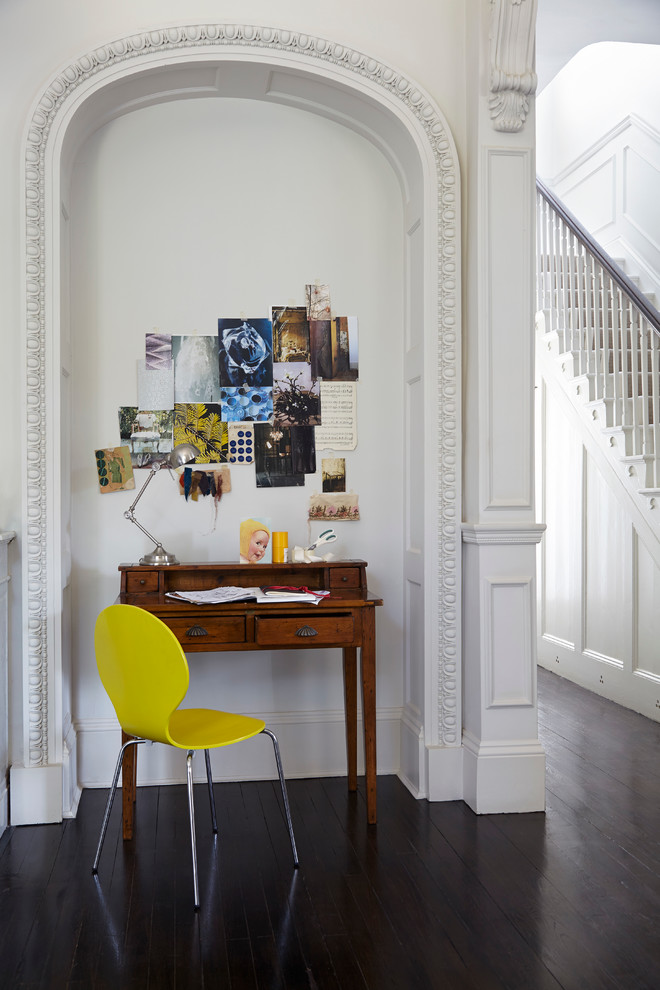 This is an example of a small contemporary study room in London with white walls, dark hardwood floors and a freestanding desk.