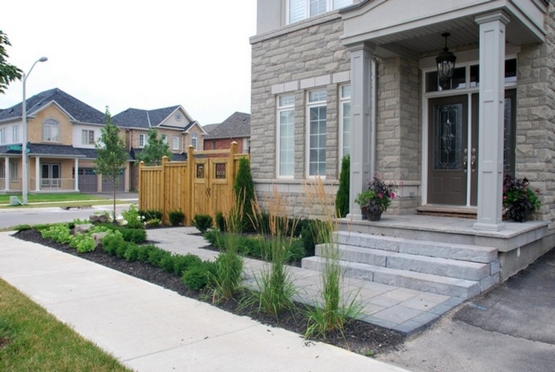 Photo of a mid-sized traditional two-storey grey house exterior in Toronto with stone veneer.